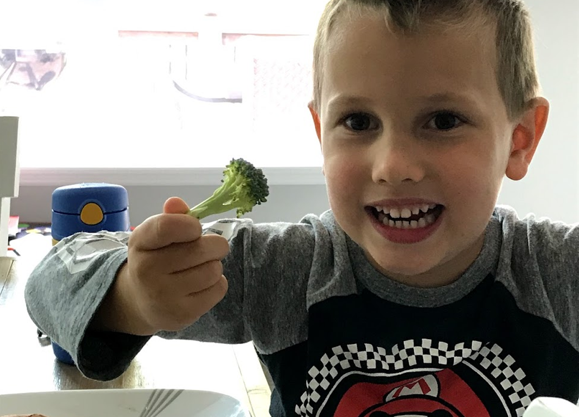 Kid eating broccoli