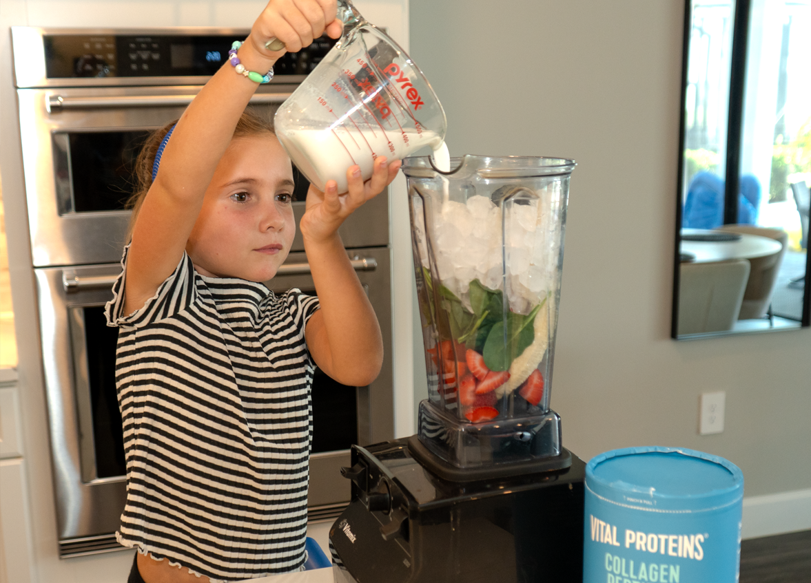 Kid making smootie in teh kitchen